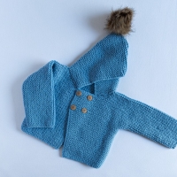 Chaquetón de lana azul con capucha y pompón de piel